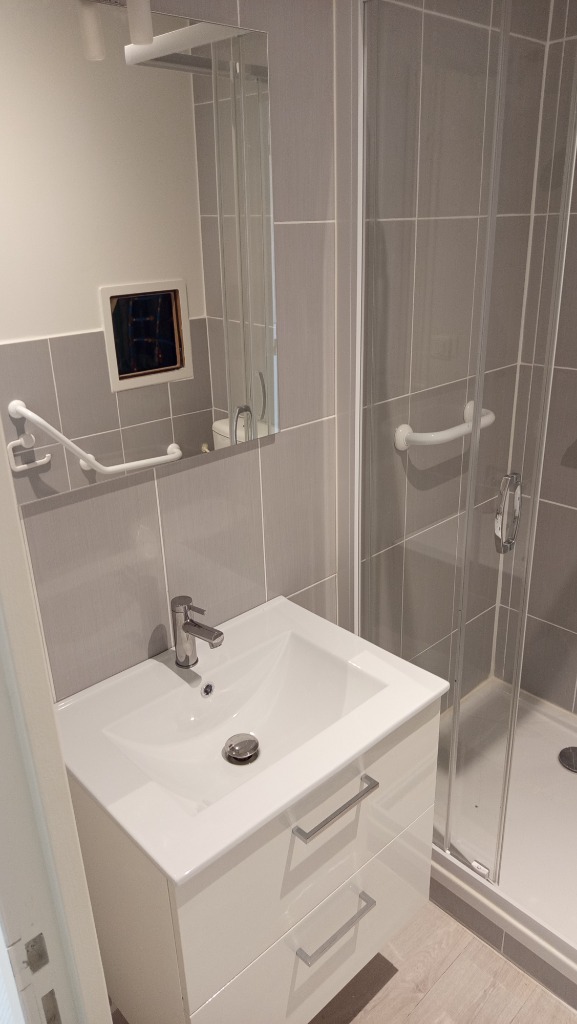 Installation d'un meuble vasque suspendu 2 tiroirs blanc laqué avec mitigeur chromé et miroir de salle de bain par un artisan plombier